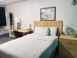 a hotel room with a bed and a desk and a bed sidx sidx sidx sidx at Tides Inn at Stehli Beach in Locust Valley