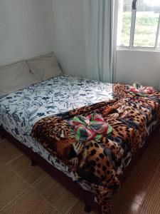 a bed with a leopard print blanket and shoes on it at Casa de Praia Maragoggi in Maragogi