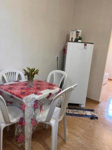 a dining room table with white chairs and a white refrigerator at Casa de Praia Maragoggi in Maragogi