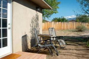 タオスにあるFully Furnished, Serene Taos Houseの家の脇の椅子2脚とテーブル