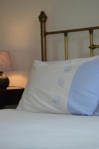 a bed with white sheets and blue pillows on it at Cottage on Diamond Street in Swakopmund