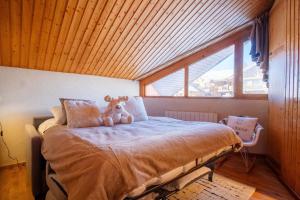 a teddy bear sitting on a bed in a room at Cosy duplex with view in Huez - Welkeys in LʼHuez