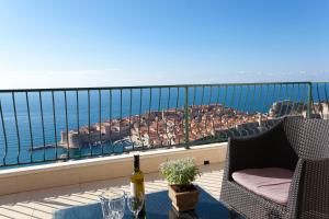 una mesa con una botella de vino en el balcón en Luxury Apartments Con Vista en Dubrovnik