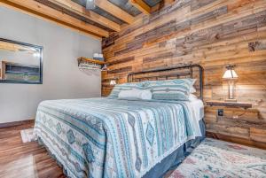 a bedroom with a bed and a wooden wall at Moonlight Ridge sleeps 8 hot tub in De Soto