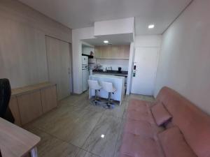 uma sala de estar com um sofá e uma cozinha em Flat Apart-hotel QI Ibirapuera Perto do Shoping em São Paulo