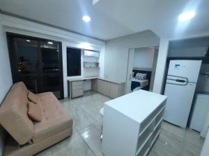 uma pequena sala de estar com um sofá e um frigorífico em Flat Apart-hotel QI Ibirapuera Perto do Shoping em São Paulo
