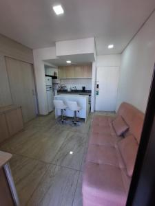 a living room with a couch and a kitchen at Flat Apart-hotel QI Ibirapuera Perto do Shoping in Sao Paulo