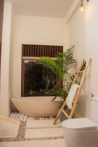 een badkamer met een bad en een plant bij Spicepeek Boutique Hotel CMB Airport in Katunayaka