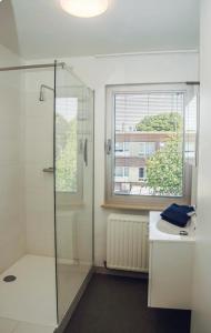 a bathroom with a shower and a sink and a window at Joseph(ine) in Antwerp