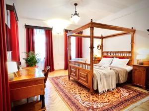 a bedroom with a canopy bed and a desk at Zentrum Vintage Appartments in Braşov