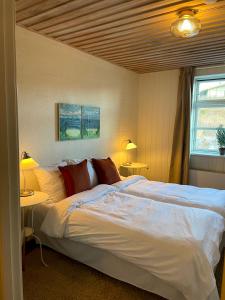a bedroom with a large white bed with two tables at Gilbjerg Strandhotel in Gilleleje