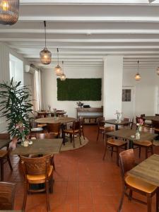 a restaurant with tables and chairs and a green screen at Gilbjerg Strandhotel in Gilleleje