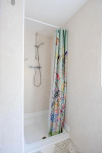 y baño con ducha y cortina de ducha. en BIG House close to Metro Underground - Sleeps up to 13, en Londres