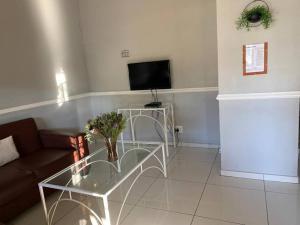 a living room with a glass table and a television at Pendleberry Grove Unit 36 in Bela-Bela