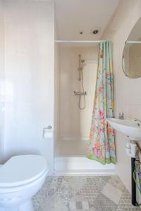 uma casa de banho com um WC e uma cortina de chuveiro em BIG House close to Metro Underground - Sleeps up to 13 em Londres