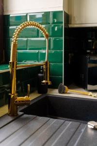 a sink in a kitchen with a gold faucet at New Slick Finnieston Pad w/ Free Parking in Glasgow