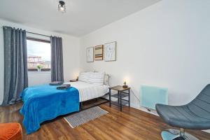 a bedroom with a bed and a chair and a window at New Slick Finnieston Pad w/ Free Parking in Glasgow