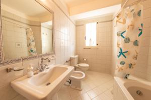 een witte badkamer met een wastafel en een toilet bij Profumi del Borgo in San Biase