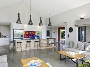 Una sala de estar con un sofá y una cocina. en Lake Taupō Luxury Home plus Hideaway Apartment, en Taupo