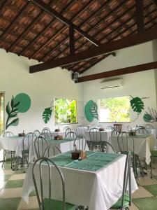 uma sala de jantar com mesas e cadeiras brancas em Pousada Ana e o Mar em Ubatuba
