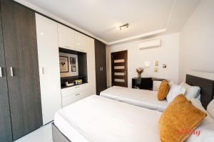 1 Schlafzimmer mit 2 Betten und einem TV in der Unterkunft Seaside Magic From a Stunning Apartment in St Paul's Bay