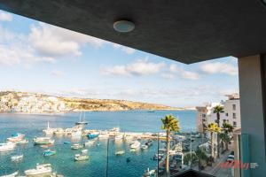 vista su un porto con barche in acqua di Seaside Magic From a Stunning Apartment a San Pawl il-Baħar