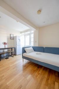 sala de estar con sofá azul y cocina en Heads Down & Coffee Mornings, en Londres