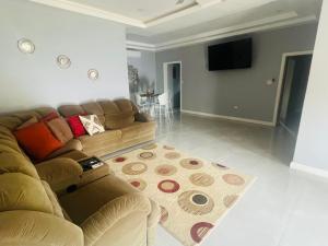 a living room with a couch and a flat screen tv at Large Contemporary Two Bedroom in Kingston