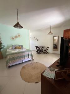 a bedroom with a bed and a tv in it at Chales Canto dos Pássaros Boipeba in Ilha de Boipeba