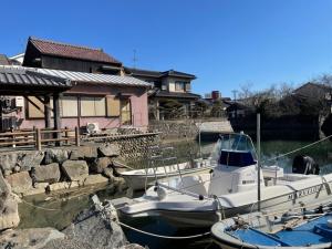 two boats docked in the water next to a house at Mugi no Oyado "Mizube" - Vacation STAY 45537v in Kuwana