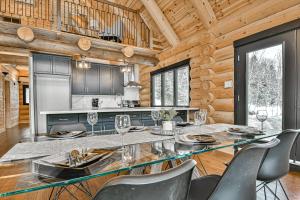 a dining room with a glass table and chairs at Le Chalet Enchanté in Saint-Donat-de-Montcalm