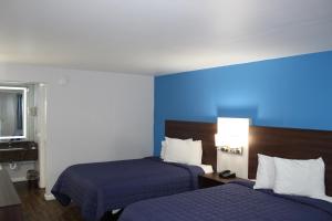 Habitación de hotel con 2 camas y pared azul en Knights Inn St. George, en Saint George