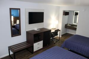 Habitación de hotel con cama y escritorio con espejo. en Knights Inn St. George, en Saint George