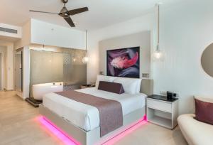 a bedroom with a bed and a bath room with a tub at Royalton CHIC Punta Cana, An Autograph Collection All-Inclusive Resort & Casino, Adults Only in Punta Cana