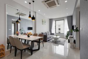 a dining room and living room with a table and chairs at Smile Home Tresor apartment - Modern comfortable in Ho Chi Minh City