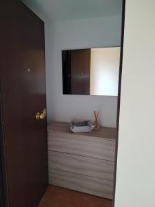 een kamer met een spiegel en een televisie aan de muur bij Mansarda con terrazzo in Barletta