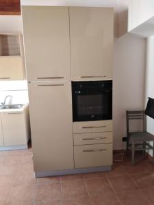 una cocina con un gran armario blanco con microondas en Mansarda con terrazzo, en Barletta