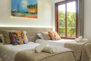 Duas camas num quarto com uma janela em Pipa ,Bosque da Praia Flat 21 em Pipa