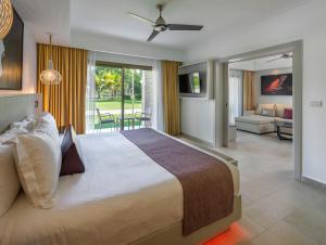 a bedroom with a large bed and a living room at Royalton CHIC Punta Cana, An Autograph Collection All-Inclusive Resort & Casino, Adults Only in Punta Cana
