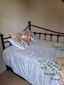 a bed with a blanket and a pillow on it at Lynthorn Farm Cottage in Frere