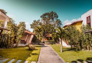 una acera en un patio con árboles y edificios en Pipa ,Bosque da Praia Flat 21 en Pipa