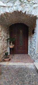 uma entrada para um edifício de pedra com uma porta de madeira em Le rondinelle em Castelnuovo Parano