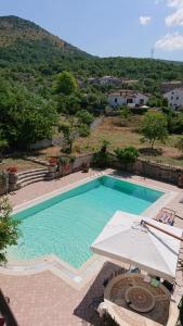 una gran piscina con sombrilla y sombrilla en Le rondinelle, en Castelnuovo Parano