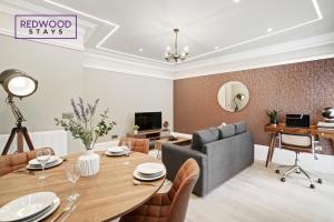 a dining room with a table and a couch at Premium 1 Bed 1 Bath Apartments For Corporates By REDWOOD STAYS in Reading