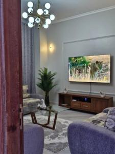 達累斯薩拉姆的住宿－Elegant Mine Apartment -1，带沙发和电视的客厅