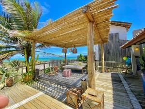 una terrazza in legno con pergolato sulla spiaggia di Casa Desert Point com Vista Única a São Gonçalo do Amarante