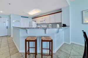 a kitchen with two bar stools and a counter top at Beach Club C-103 in Gulf Shores