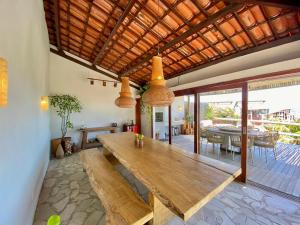 einen großen Holztisch im Wohnzimmer mit Esszimmer in der Unterkunft Casa Desert Point com Vista Única in São Gonçalo do Amarante