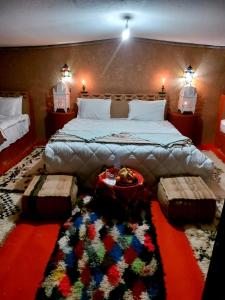 a bedroom with a large bed with a rug at Chegaga Luxury Camp in El Gouera