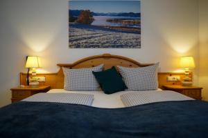 a bedroom with a bed with two lamps and a picture on the wall at HoFer am Zeitberg Ferienwohnung Ammertal in Bad Kohlgrub